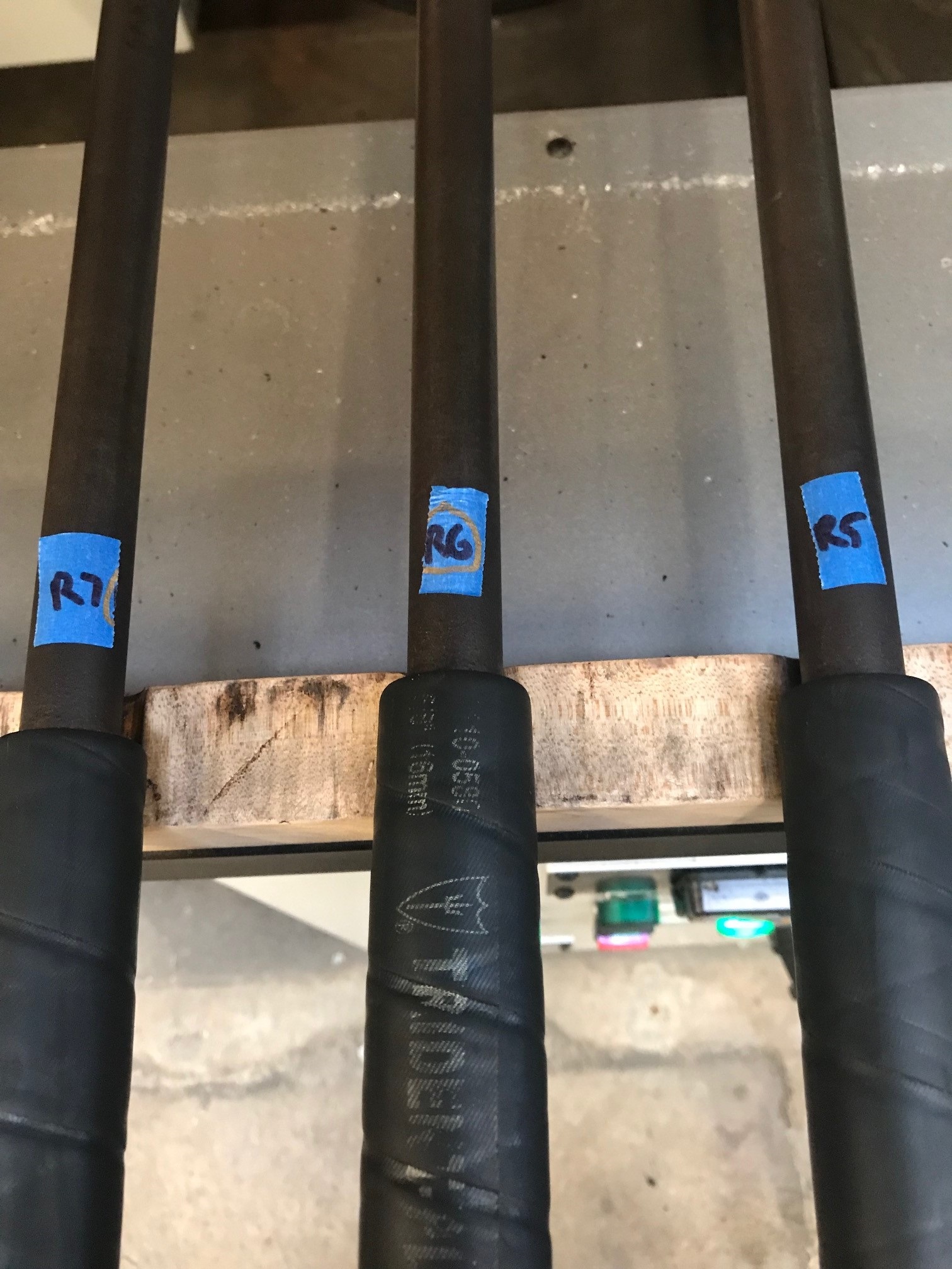 A group of four bats with blue stickers on them.