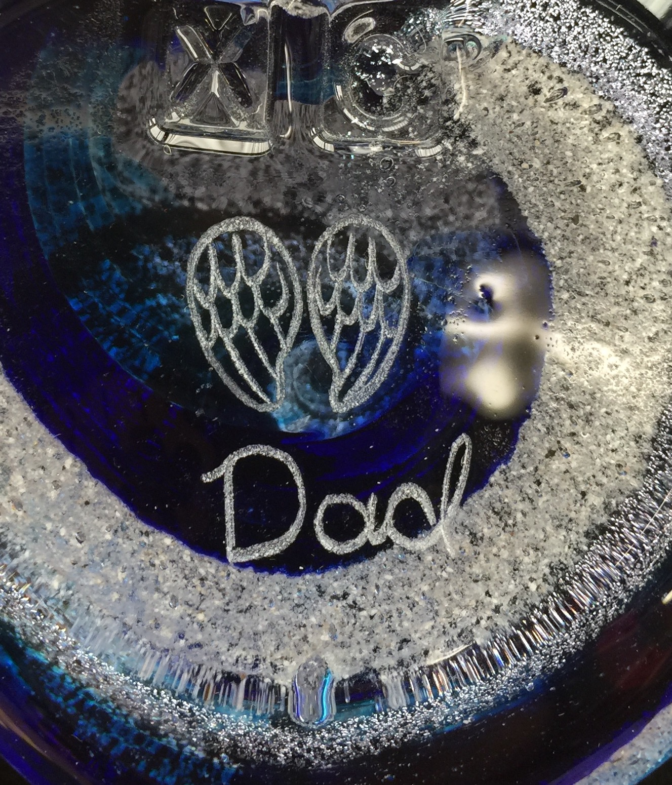 A close up of the word dad written in white ink.