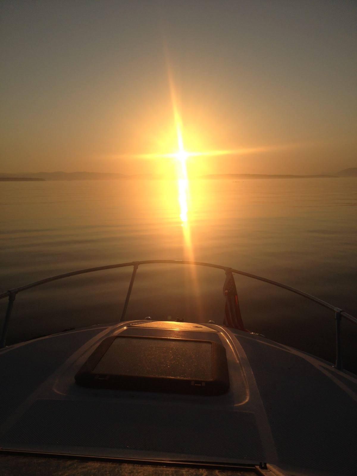 A boat is sailing on the water at sunset.