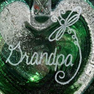 A close up of the word grandpa on a heart shaped ornament.