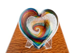 A heart shaped glass dish with swirling colors.