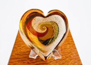 A heart shaped glass sculpture on top of a wooden table.