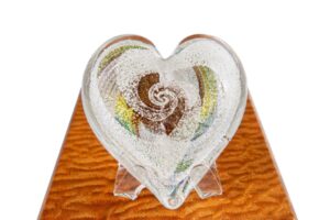 A glass heart with swirls of color on top.