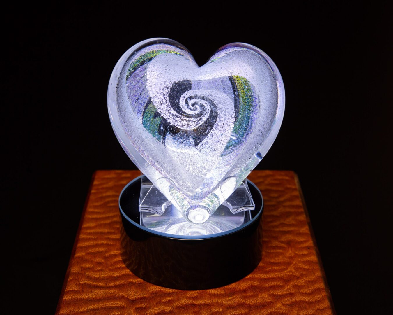 A heart shaped glass sculpture with a swirly design.