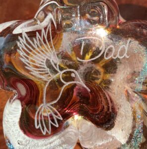 A glass sculpture of a bird and the word god