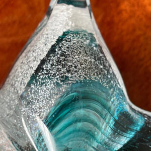 A close up of the bottom part of a glass sculpture.