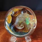 A glass ball with a swirl design on it.