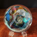 A glass bowl with some colorful shapes inside of it