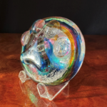 A glass sculpture of a face on top of a table.