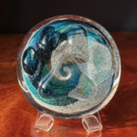 A glass bowl with blue and white swirls on top of it.