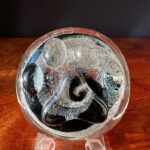 A glass sculpture of a black and white swirl.